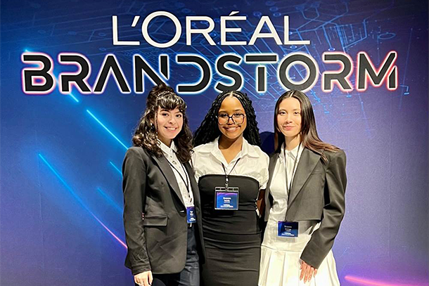 three students in front of l'oréal  sign
