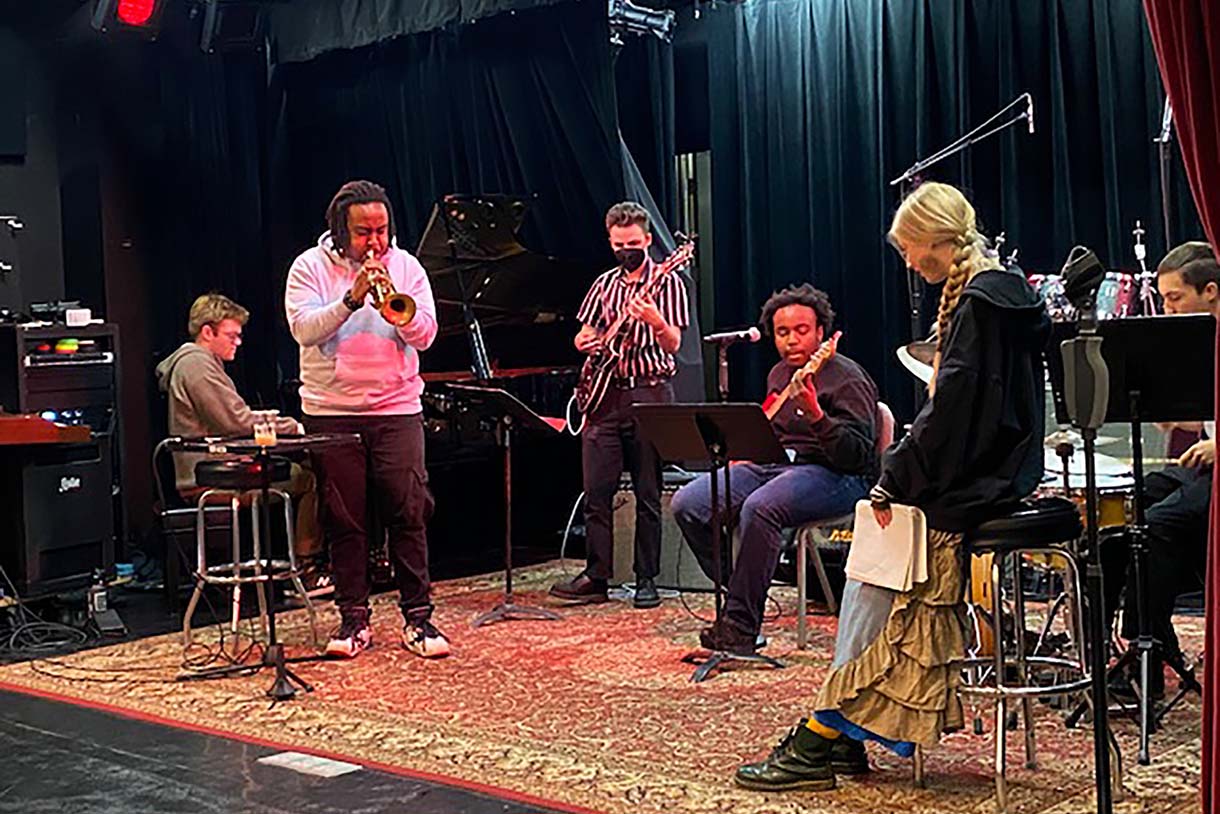 parris fleming performs trumpet on stage with columbia college chicago students