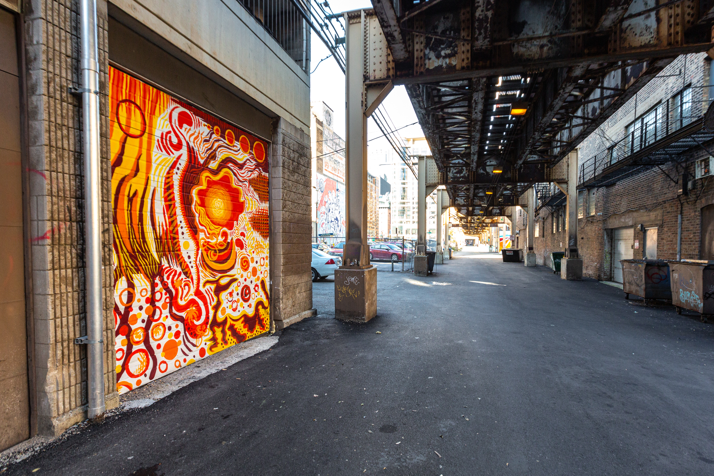 Photo of orange mural underneath train tracks