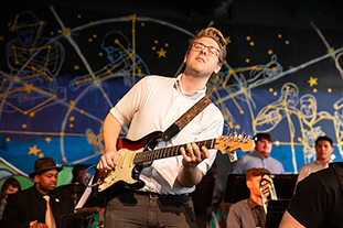 Student playing a guitar