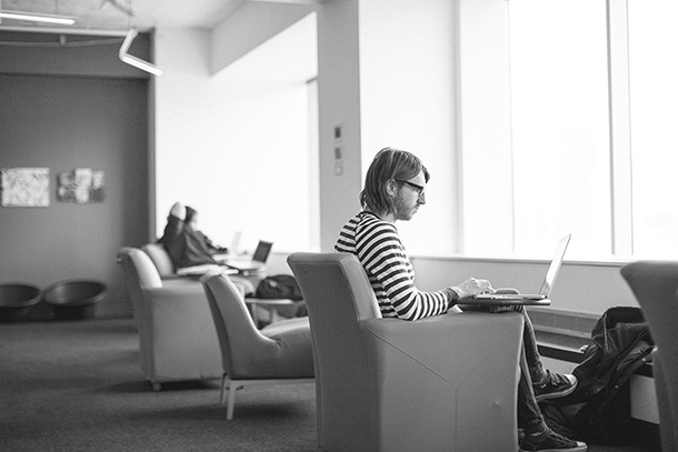 student sitting in chair using laptop