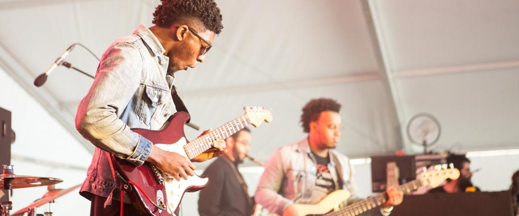 two students playing guitar on stage at festival