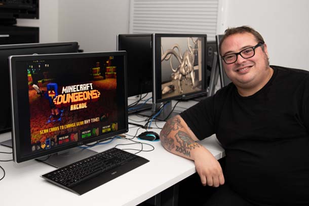 faculty member John Losacco sitting at a desk in front of computer monitors