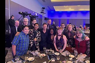 Students and faculty with Ryan Seacrest at even table.