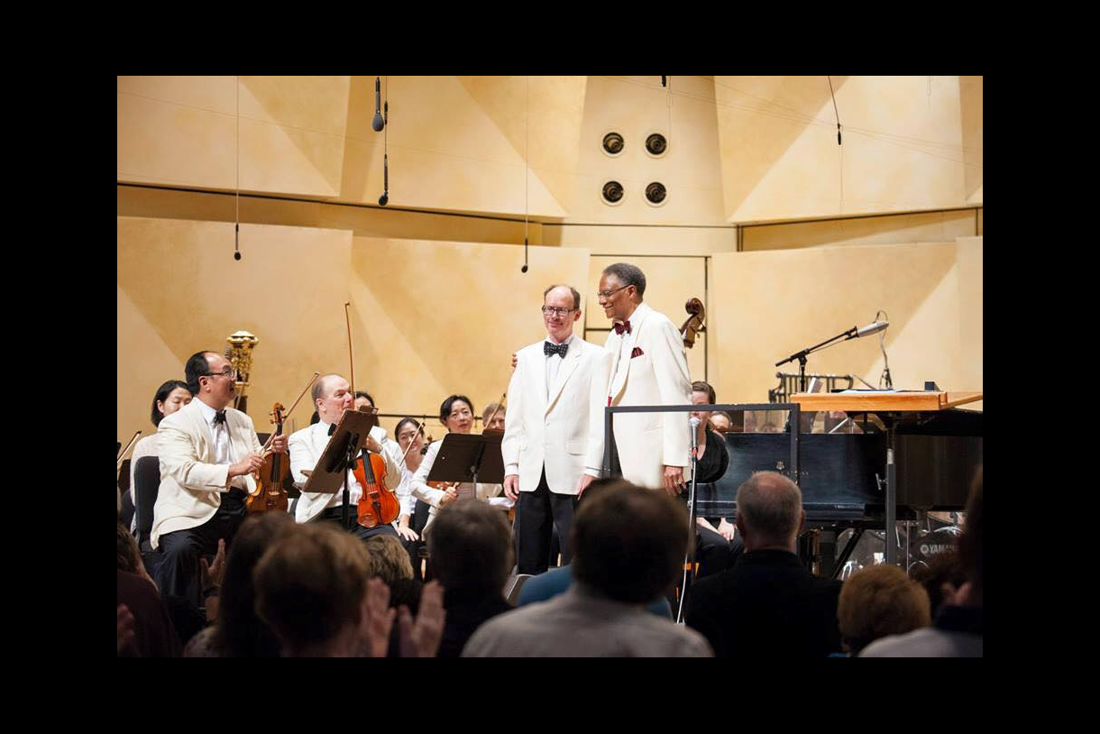 Photo of Scott Hall (standing, left) with Ramsey Lewis (standing, right) at a Hall-conducted CSO premier of Concerto for Jazz Trio and Orchestra by Lewis and arranged by Hall. 