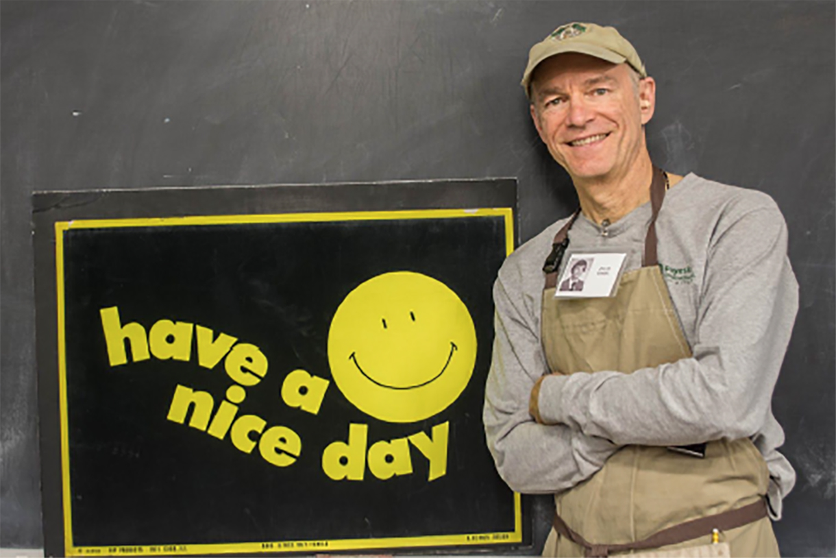 Dave in front of a poster that reads "Have a nice day"