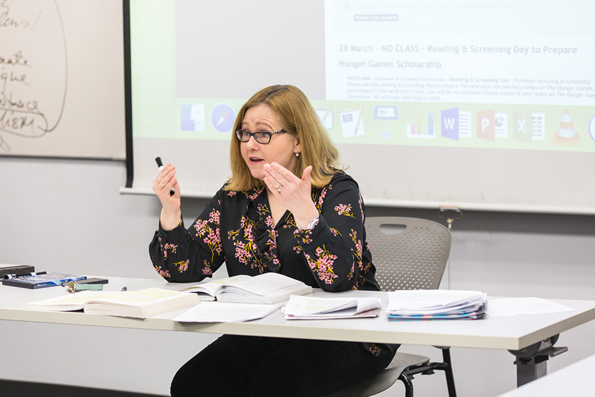 Ann Gunkel sitting at a desk leading a classroom discussion