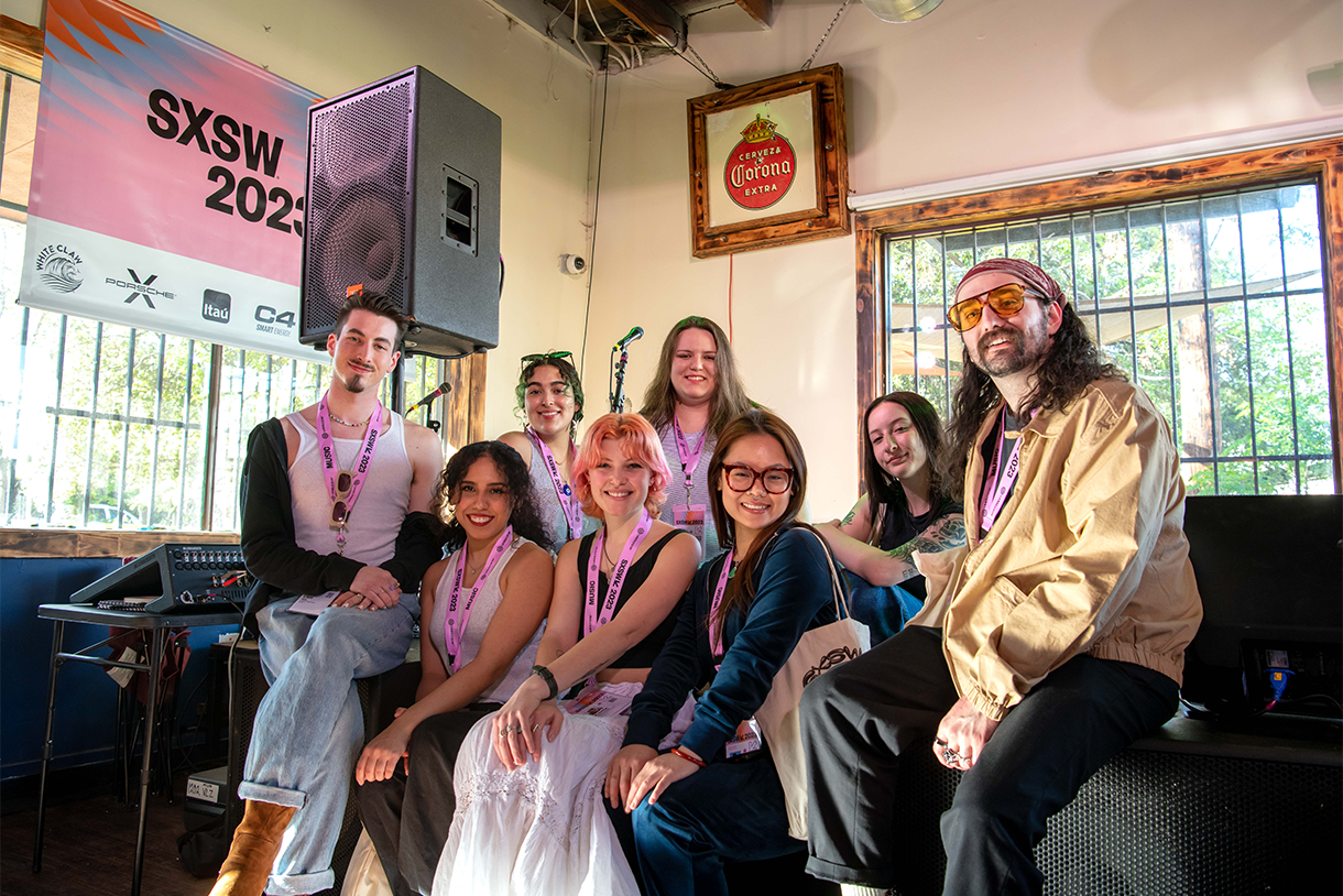 group of students sitting on stage at music venue