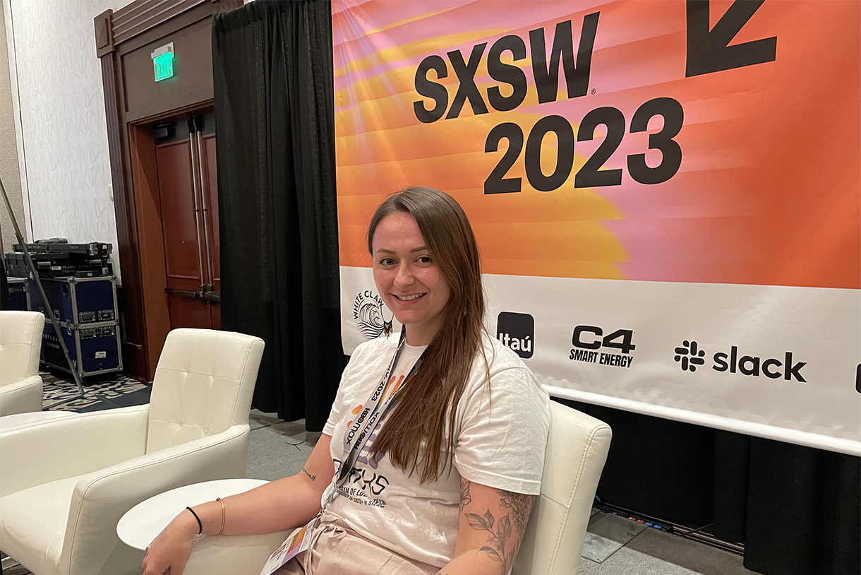 alum kristen kelley seated in front of sxsw signage