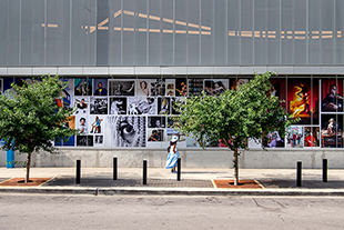 a wide shot of an outdoor installation a woman walking past stops to look