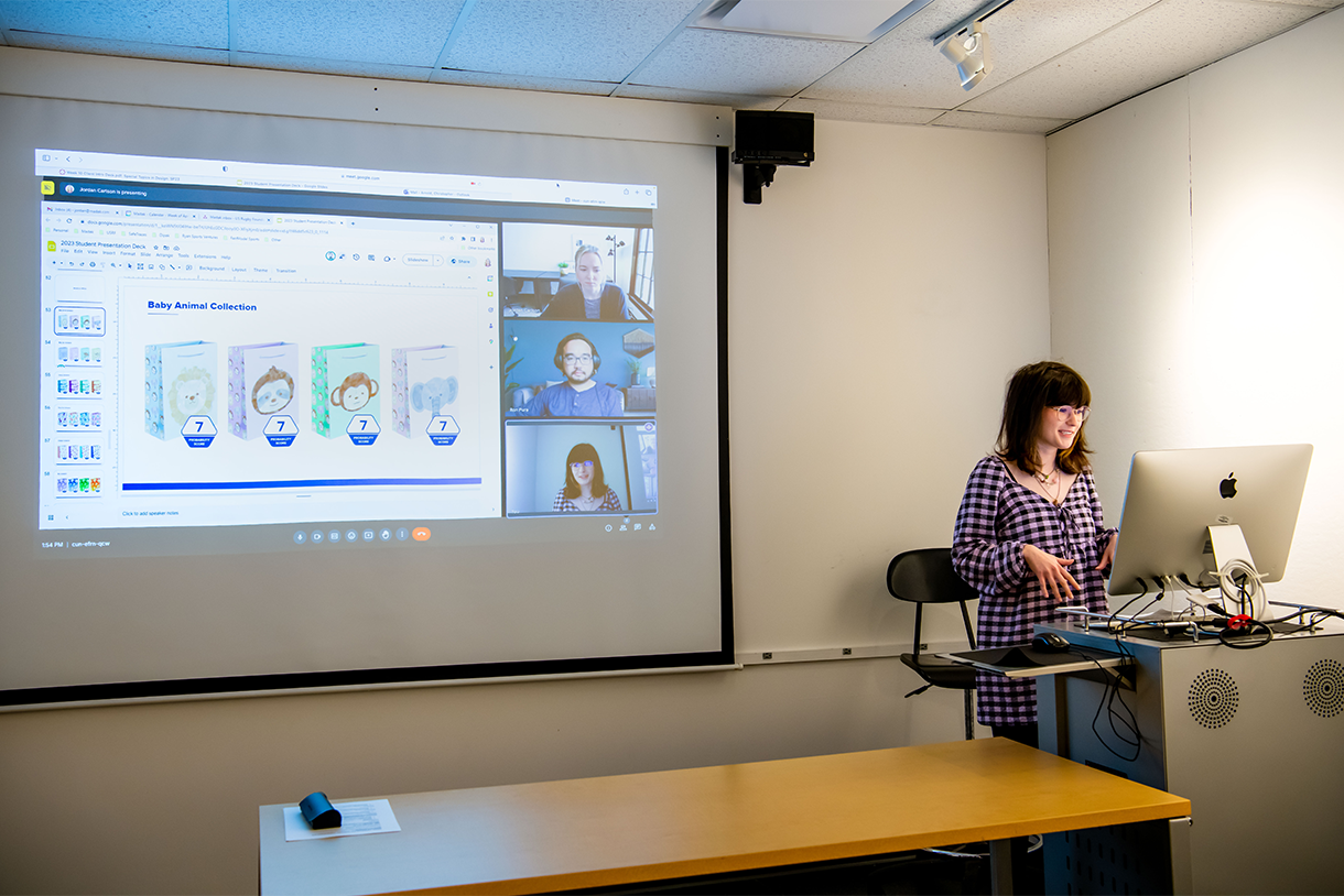 student at podium with zoom video call image on screen behind student
