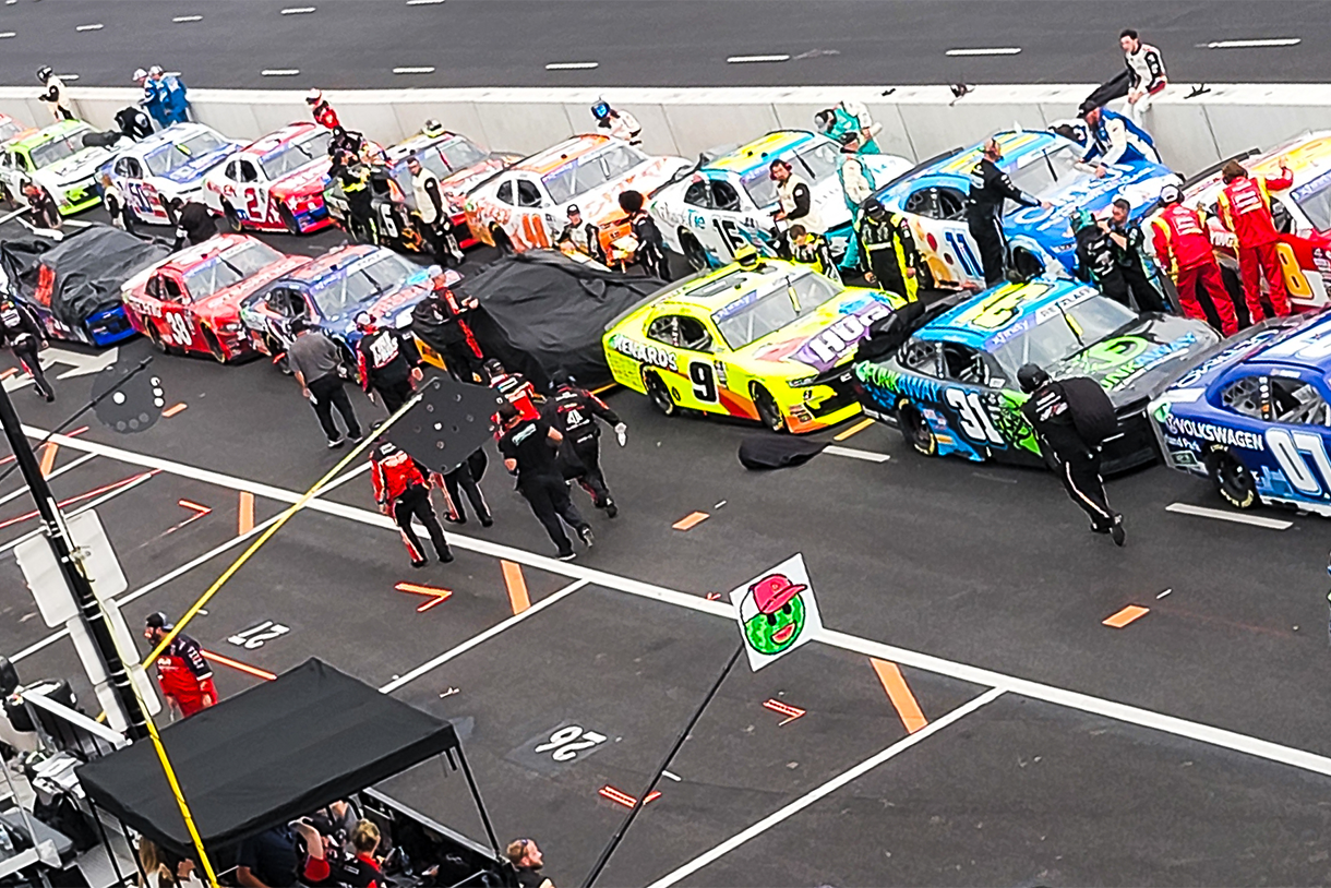 nascar cars lined up in a row on street