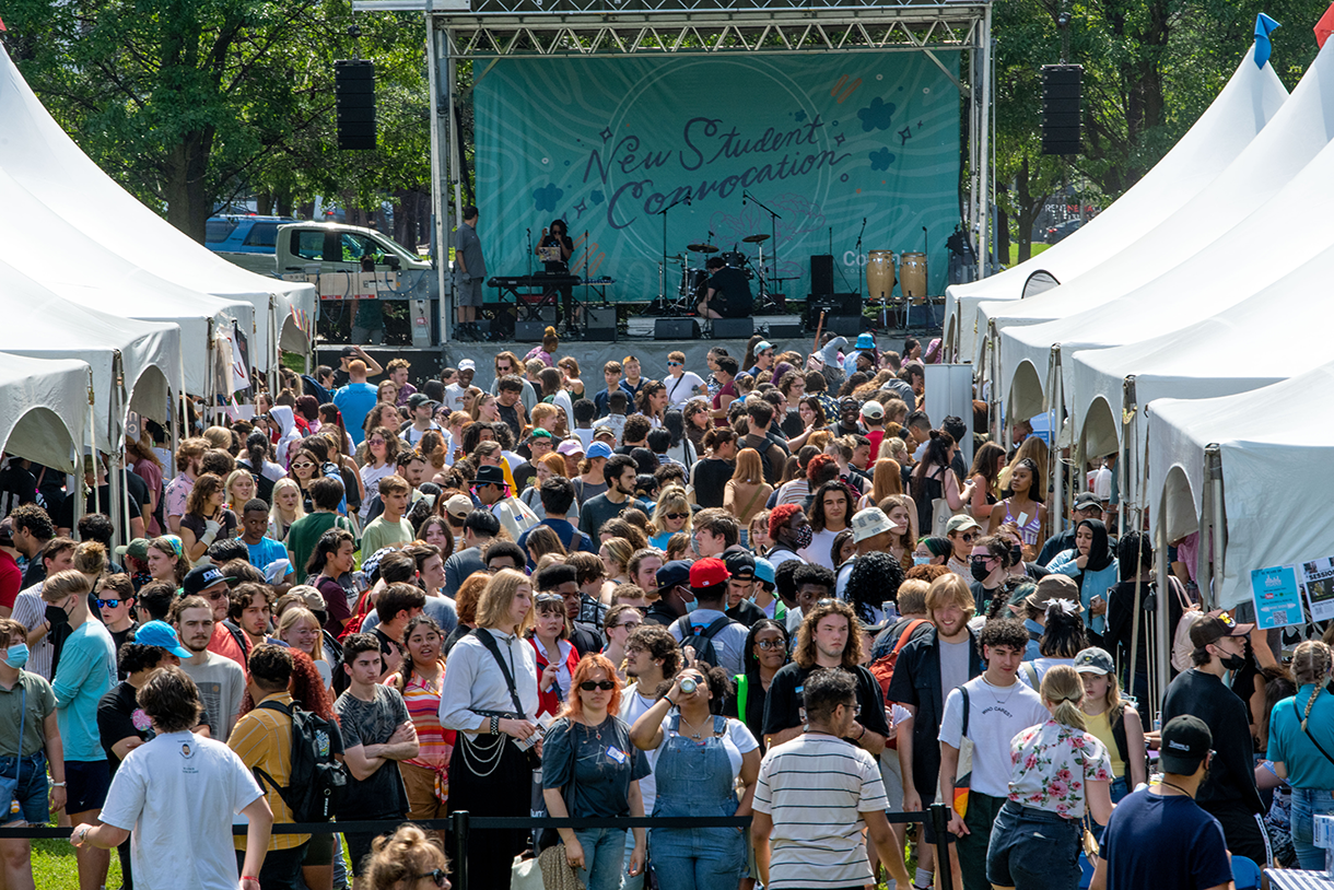 student convocation stage with outdoor crowd and tents