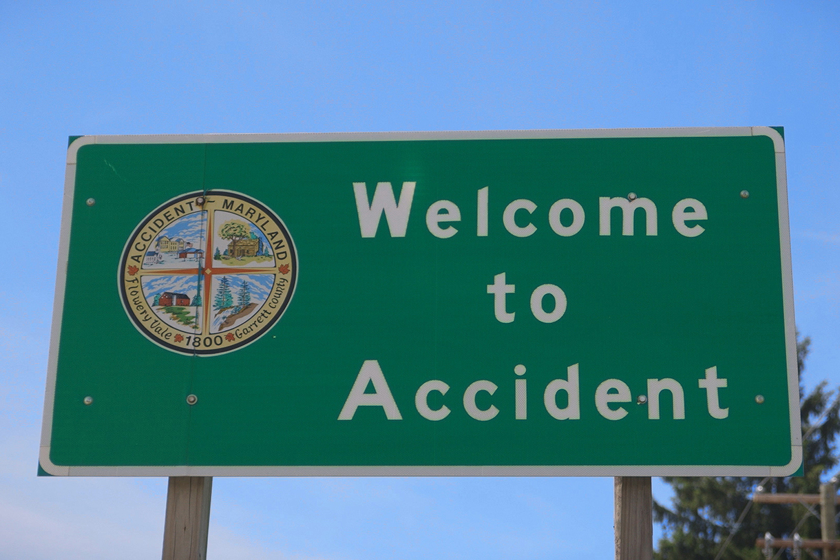 green highway sign that says Welcome to Accident